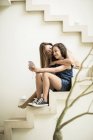 Donna e ragazza seduti su gradini esterni — Foto stock