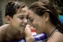 Donna e ragazzo coccole in piscina . — Foto stock