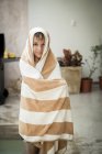 Niño de pie envuelto en toalla - foto de stock