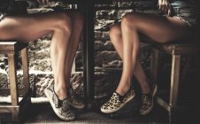 Legs of two women under table. — Stock Photo