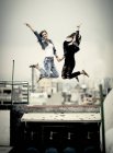 Mulheres pulando no telhado — Fotografia de Stock