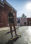 Woman and man skateboarding and rollerskating — Stock Photo
