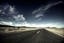 Estrada rural através da paisagem do deserto — Fotografia de Stock