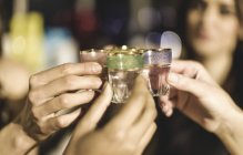 Group at party holding shot glasses — Stock Photo