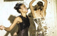 Junge Frauen tanzen mit fallendem Konfetti. — Stockfoto