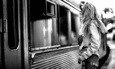 Mulher de pé na estação ferroviária — Fotografia de Stock