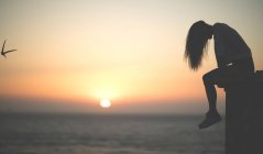 Jeune femme au coucher du soleil — Photo de stock