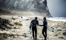 Surfers carrying surfboards — Stock Photo