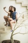 Woman and girl sitting on outdoor steps — Stock Photo