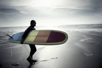 Mann trägt Surfbrett. — Stockfoto