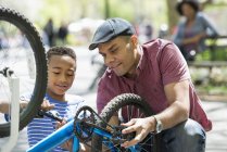 Father and son repairing a bicycle. — Stock Photo