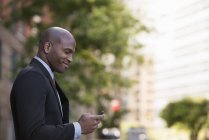 Side view of man in suit checking phone. — Stock Photo
