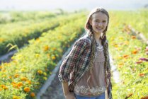 Adolescente de pé no campo de flores — Fotografia de Stock