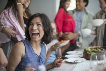 Woman laughing at dinner with adults and children around table. — Stock Photo