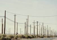 Strommasten auf einem Ölfeld bei Sonnenuntergang in Kalifornien, USA — Stockfoto