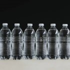 Filas de botellas de agua de plástico transparente llenas de agua filtrada . - foto de stock
