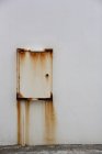 Wall-mounted metal box with rust stains. — Stock Photo