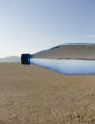 Пляшка води в ландшафті чорний пустелі рок в штаті Невада — стокове фото