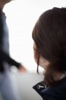 Close-up of woman with brown hair turning away indoors. — Stock Photo