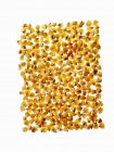 Yellow corn maize kernels arranged in pattern on white background. — Stock Photo