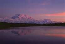 Puesta de sol en el Monte McKinley reflejándose en el lago en el Parque Nacional Denali, Alaska . - foto de stock