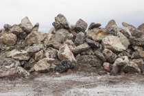 Grande mucchio di rocce usate impilate sulla riva del mare
. — Foto stock