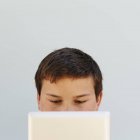 Portrait of teenage boy holding digital tablet covering half face. — Stock Photo