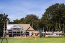 Rural building site with scaffolding in woodland. — Stock Photo