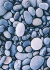 Polished smooth stones and pebbles on sea shore, full frame. — Stock Photo