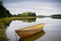 Piccola barca a remi in legno ormeggiata in acque calme nel porto di Savage sull'isola Principe Edoardo in Canada
. — Foto stock