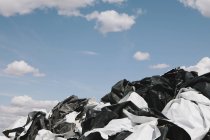Sacchetti di plastica scartati in bianco e nero contro il cielo blu . — Foto stock