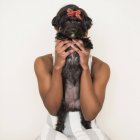 Ragazza adolescente tenendo piccolo cane da compagnia nero in mano . — Foto stock