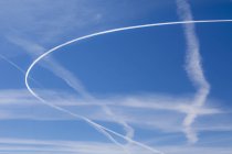 Jet senderos a través del cielo azul, marco completo . - foto de stock