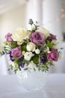Arreglo de flores de boda blancas, rosadas y moradas en jarrón de vidrio . - foto de stock