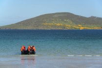 Group of people in rubber boat landing on beach on Falkland Islands. — Stock Photo