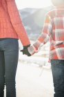 Cropped view of children holding hands in winter landscape. — Stock Photo