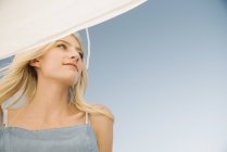 Портрет блондинки молодої жінки під вітрилом на човні проти блакитного неба . — стокове фото