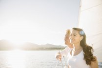 Mann und Frau genießen Sonnenlicht auf Segelboot. — Stockfoto