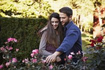 Young man and woman looking at plants on display at garden center. — Stock Photo