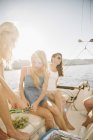 Mother with teenage daughters eating grapes on sailboat. — Stock Photo