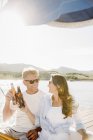 Mann und Frau relaxen auf Segelboot mit Bierflaschen. — Stockfoto