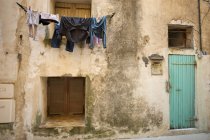 Laundry drying on washing line outside house in Bonifacio on Corsica. — Stock Photo