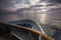 Coast of ocean and bow of cruise ship at dawn in France. — Stock Photo