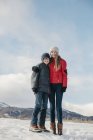 Hermano y hermana de pie lado a lado en el paisaje nevado . - foto de stock