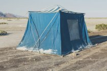 Vecchia tenda da campeggio blu fangosa nel deserto di Bonneville Salt Flats, Utah, Stati Uniti d'America . — Foto stock