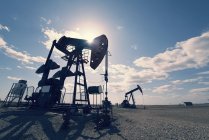 Pump jack in open ground at oil extraction site. — Stock Photo