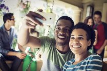 Paar macht Selfie mit Gruppe von Freunden bei Hausparty. — Stockfoto