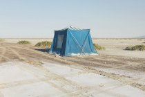 Old muddy blue camping tent in desert of Bonneville Salt Flats, Utah, USA.. — Stock Photo