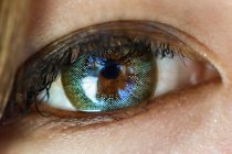 Nahaufnahme des weiblichen Auges mit Kontaktlinse und Reflexion. — Stockfoto