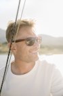Portrait of blond man with sunglasses on sailboat. — Stock Photo